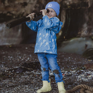 Boy wearing Snapper Rock Adventurewear raincoat holding telescope.