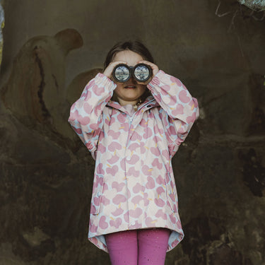 Girl looking out to sea through binoculars wearing pink raincoat from Snapper Rock.