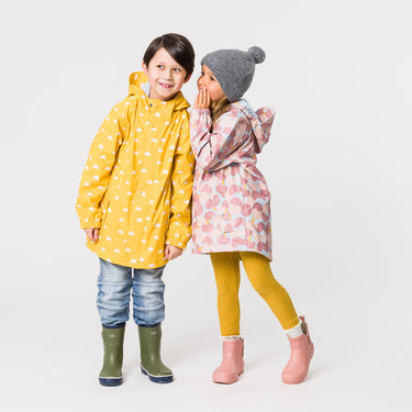 Girl whispering to boy, wearing waterproof kids raincoats.